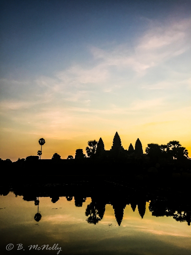A variety of colors are seemingly painted across the sky as the sun rises over Angkor Wat.